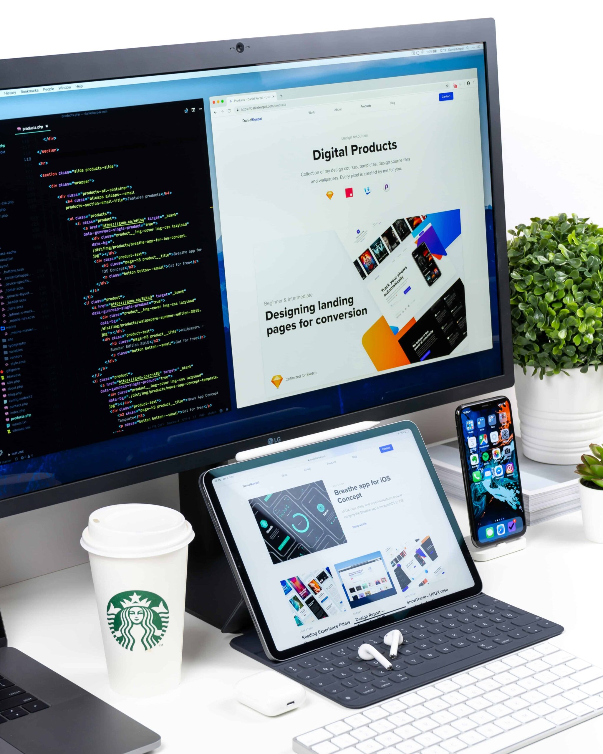 Bureauopstelling met een grote monitor, tablet en smartphone waarop code en een portfolio website te zien zijn, naast een koffiebeker en plant.